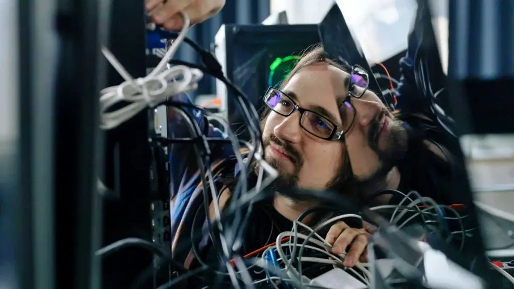 Man working on equipment in data rack - photo by cottonbro studio on pexels