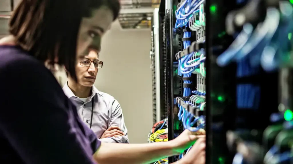 woman and man technicians working on computer server farm